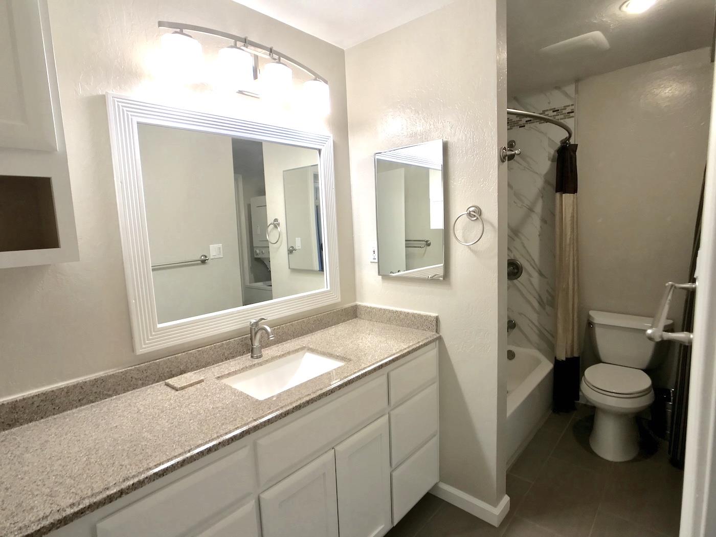1925 46th Avenue, Unit 60 Capitola, CA 95010 - Photo 13 of 26 a bathroom with a sink a toilet a shower and a mirror