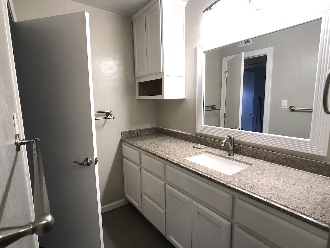 1925 46th Avenue, Unit 60 Capitola, CA 95010 - Photo 14 of 26 a bathroom with a granite countertop sink and a mirror