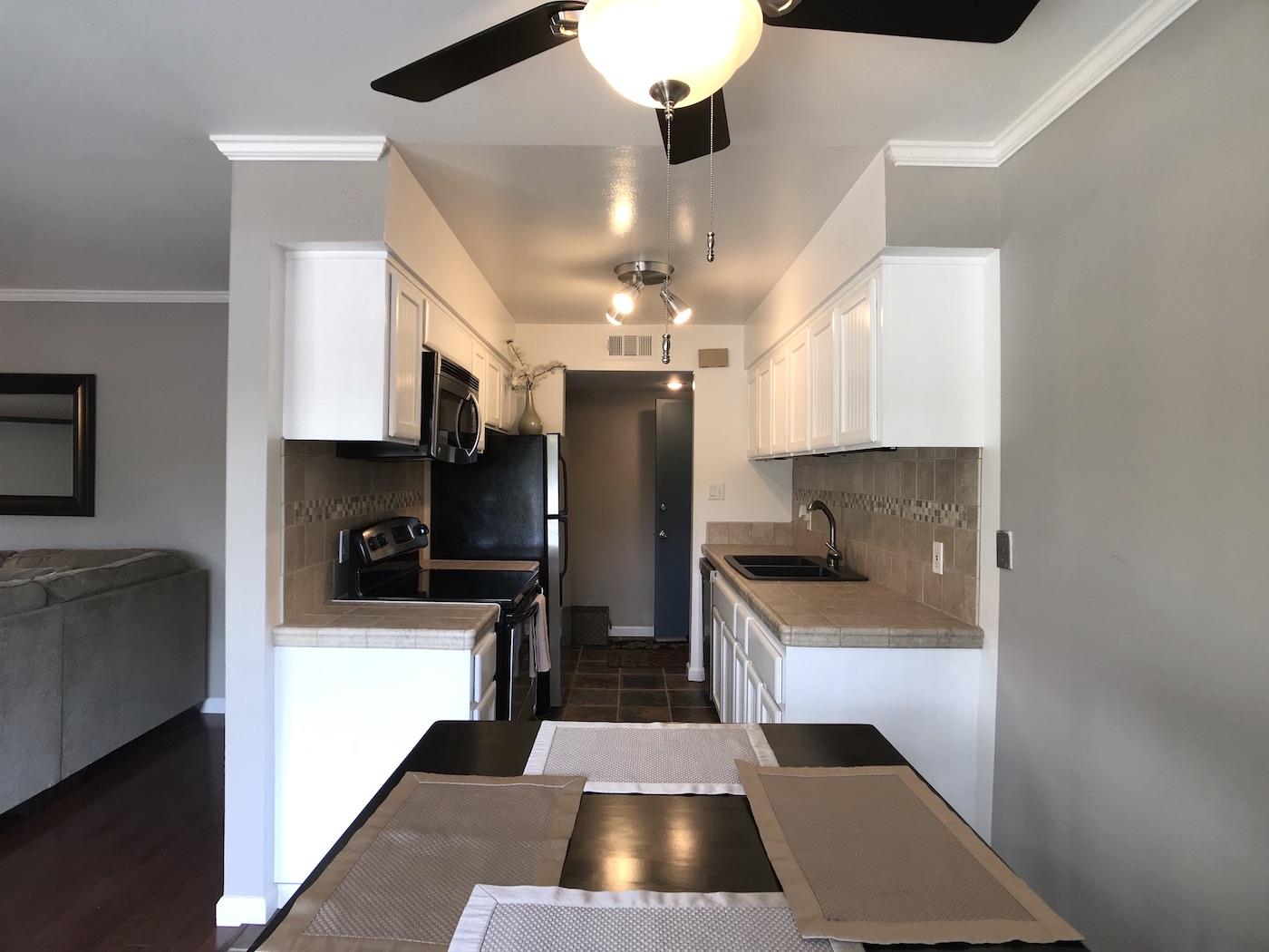 1925 46th Avenue, Unit 60 Capitola, CA 95010 - Photo 2 of 26 a kitchen with stainless steel appliances kitchen island granite countertop a refrigerator and a stove top oven