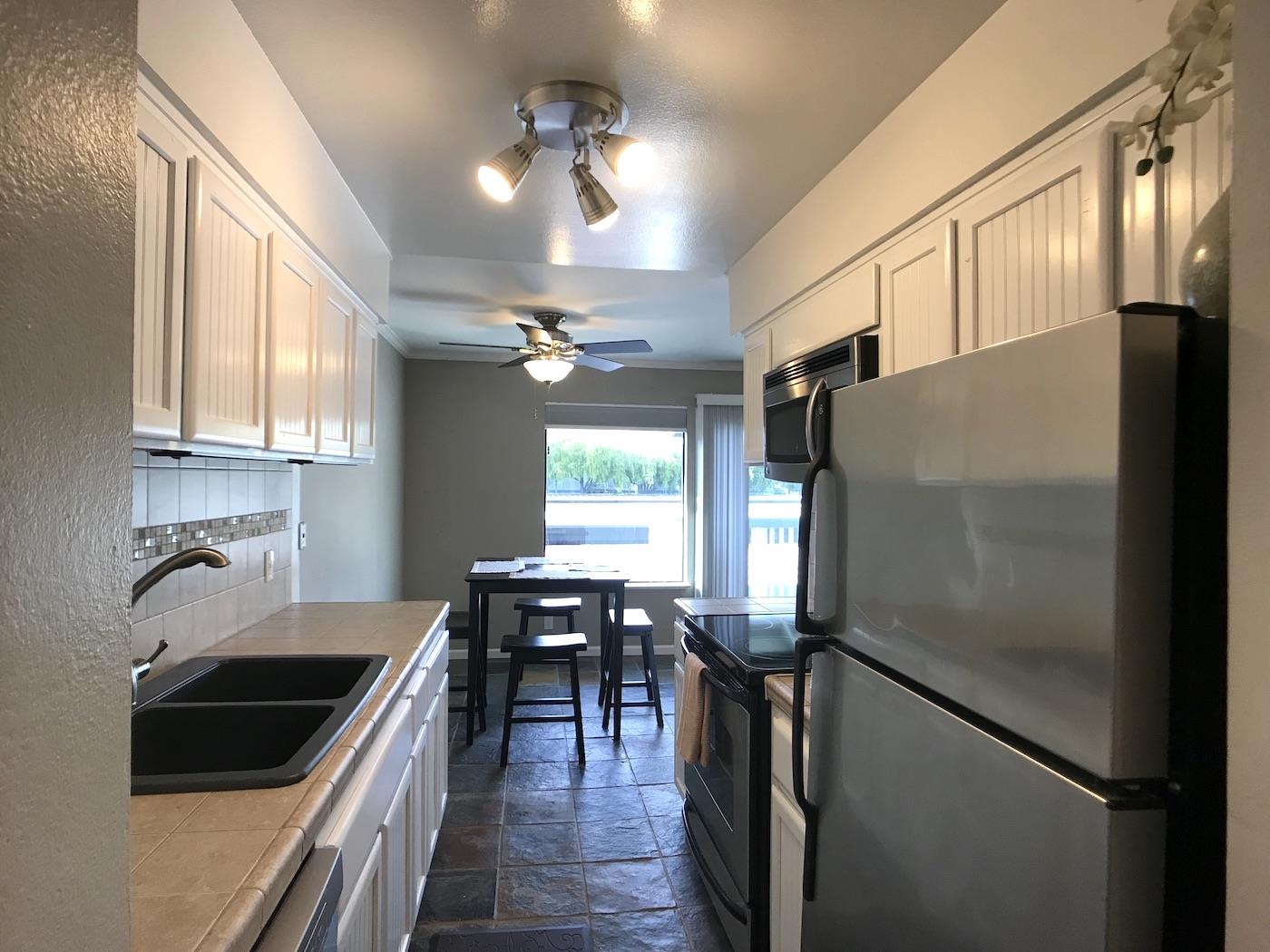 1925 46th Avenue, Unit 60 Capitola, CA 95010 - Photo 3 of 26 a kitchen with kitchen island a counter top space appliances and cabinets