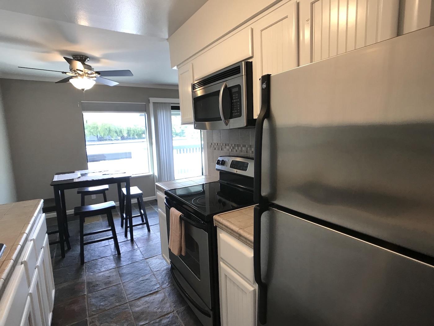 1925 46th Avenue, Unit 60 Capitola, CA 95010 - Photo 5 of 26 a kitchen with granite countertop a stove cabinets and microwave