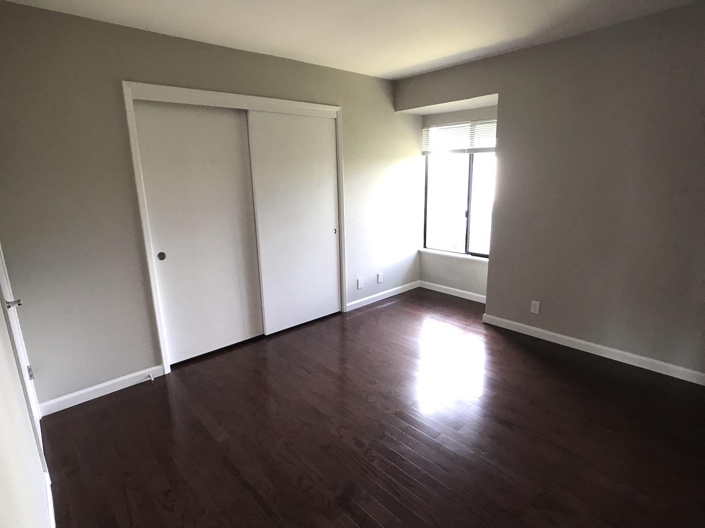 1925 46th Avenue, Unit 60 Capitola, CA 95010 - Photo 10 of 26 an empty room with wooden floor and windows