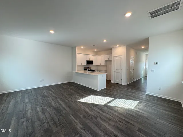 a view of a kitchen with wooden floor and a sink