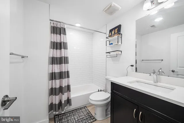 a bathroom with a sink a toilet a shower and a mirror