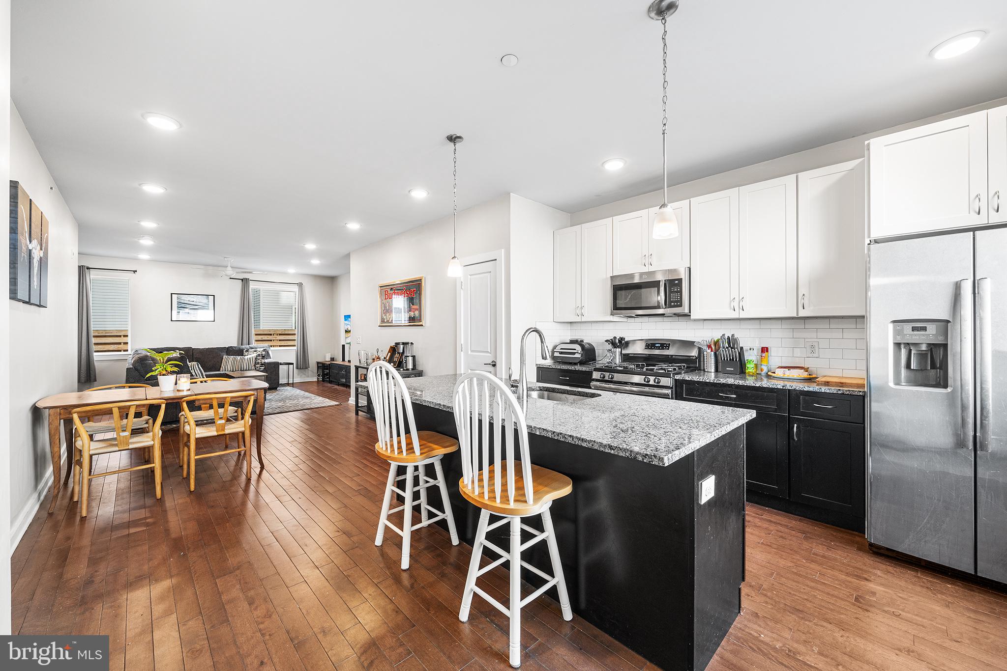 1640 North 5th Court, Unit 29A Philadelphia, PA 19122 - Photo 3 of 21 a kitchen with stainless steel appliances granite countertop a stove top oven a refrigerator a sink and white cabinets with wooden floor