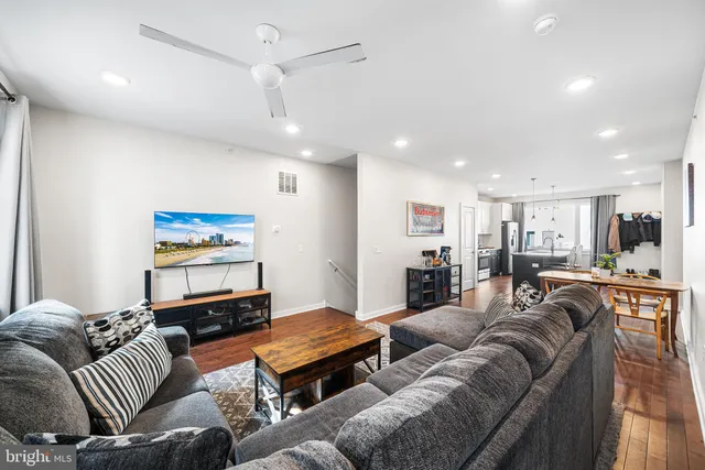 a living room with furniture kitchen view and a flat screen tv