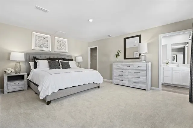 a spacious bedroom with a bed and dresser