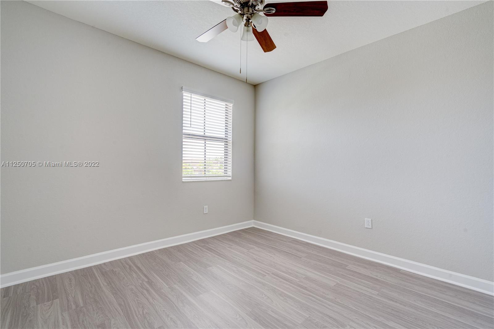 124 Northeast 25th Avenue Homestead, FL 33033 - Photo 12 of 32 wooden floor in an empty room with a window