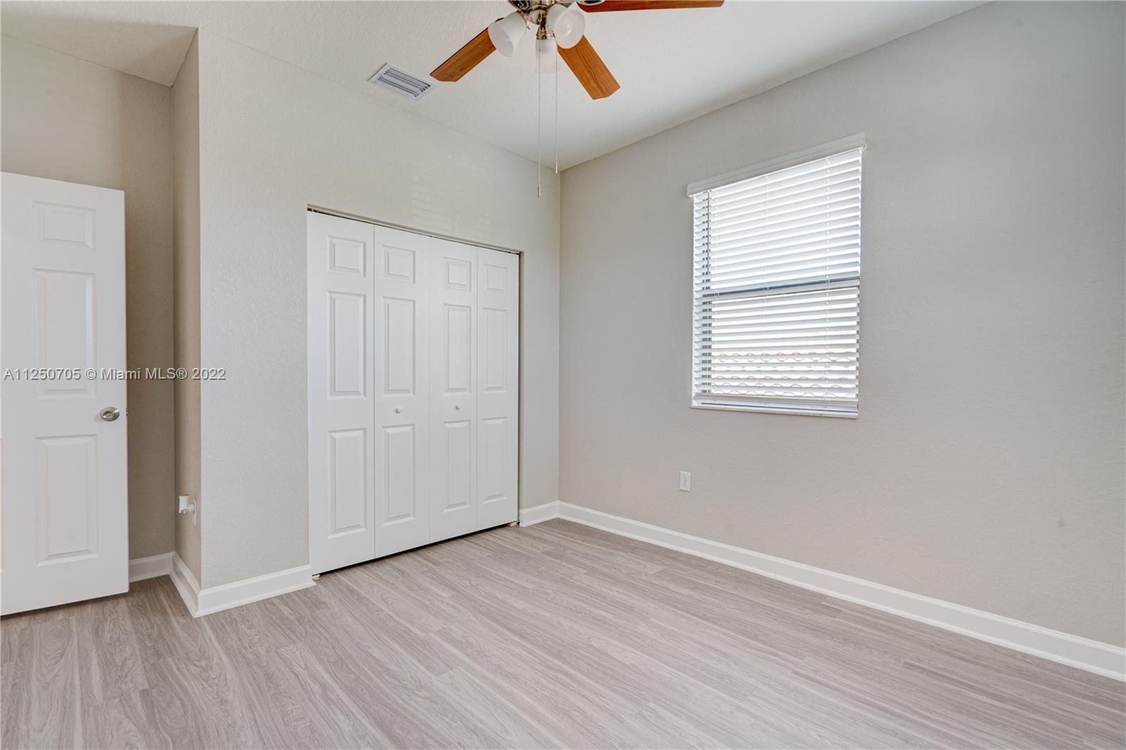 124 Northeast 25th Avenue Homestead, FL 33033 - Photo 16 of 32 an empty room with wooden floor and windows