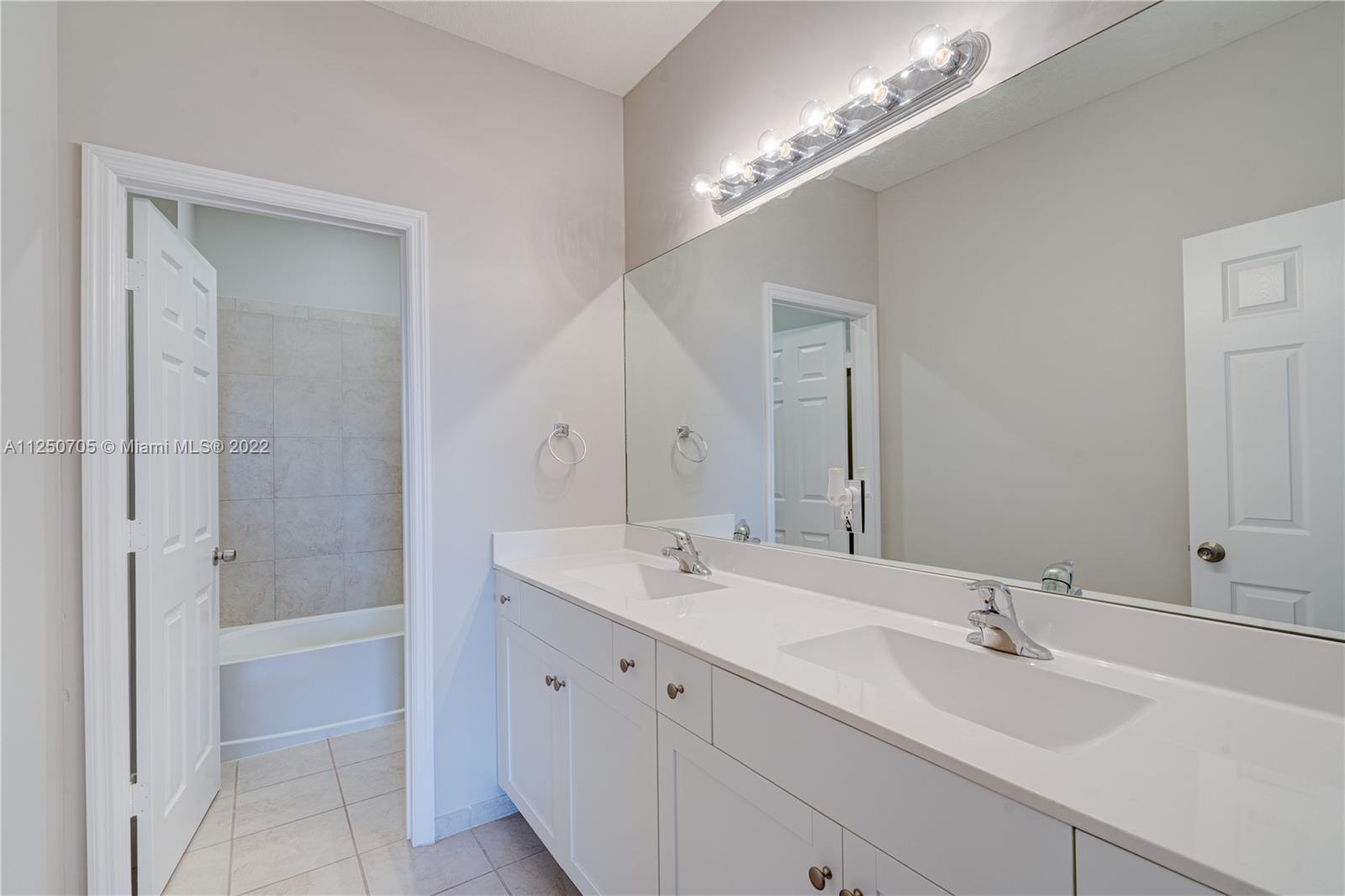 124 Northeast 25th Avenue Homestead, FL 33033 - Photo 17 of 32 a bathroom with a sink a shower and a mirror