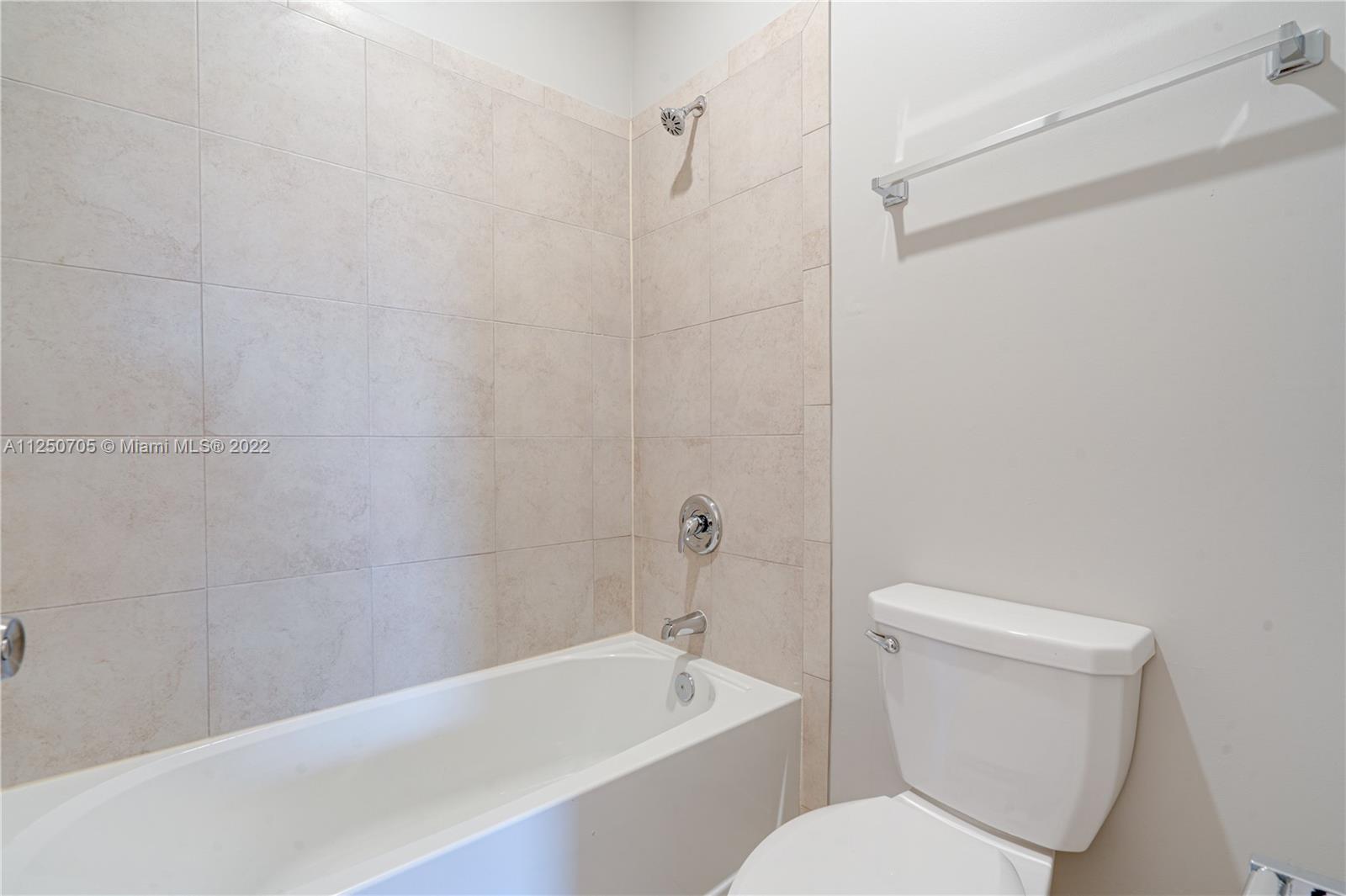 124 Northeast 25th Avenue Homestead, FL 33033 - Photo 18 of 32 a white toilet and tub sitting next to a bathroom sink
