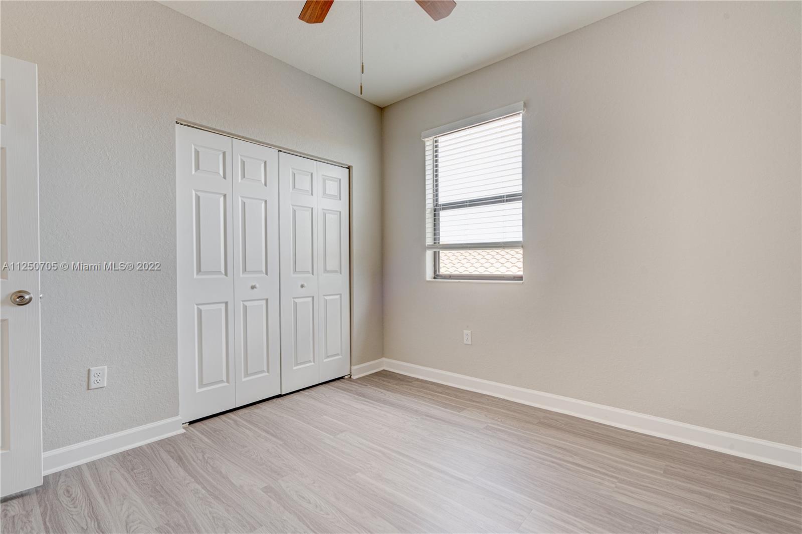 124 Northeast 25th Avenue Homestead, FL 33033 - Photo 20 of 32 an empty room with wooden floor and windows