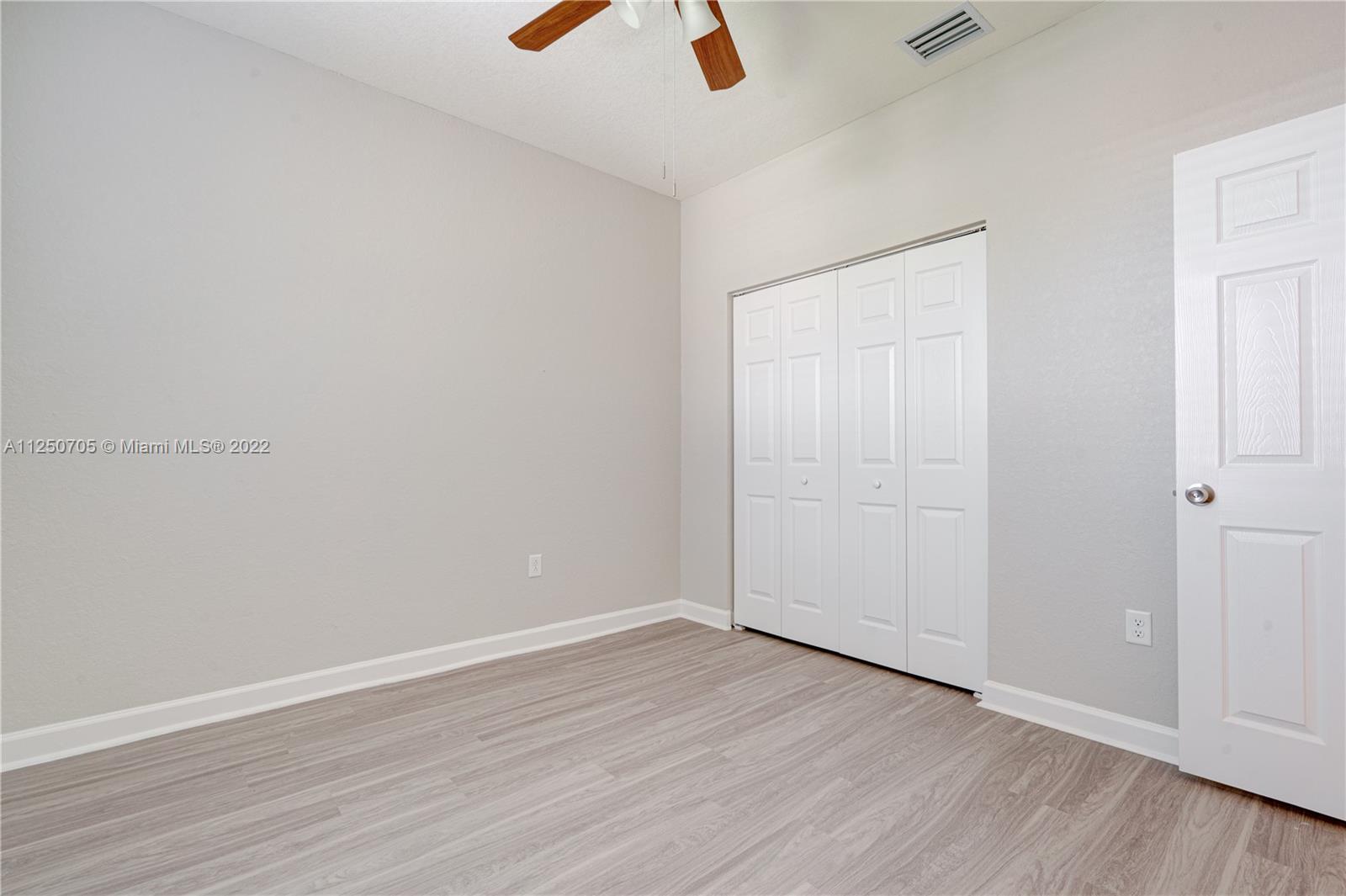 124 Northeast 25th Avenue Homestead, FL 33033 - Photo 22 of 32 an empty room with wooden floor and windows