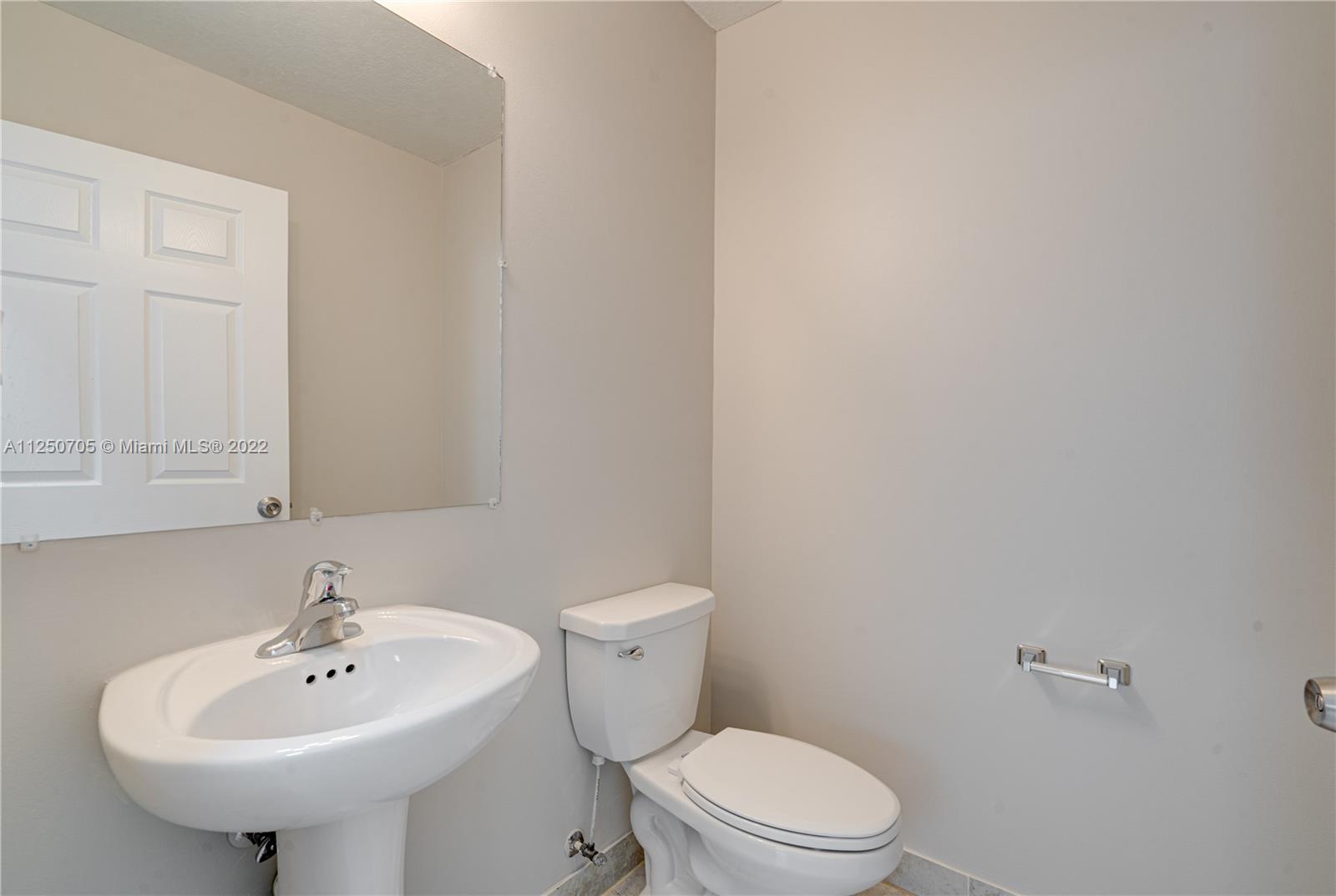 124 Northeast 25th Avenue Homestead, FL 33033 - Photo 10 of 32 a bathroom with a sink a toilet and mirror