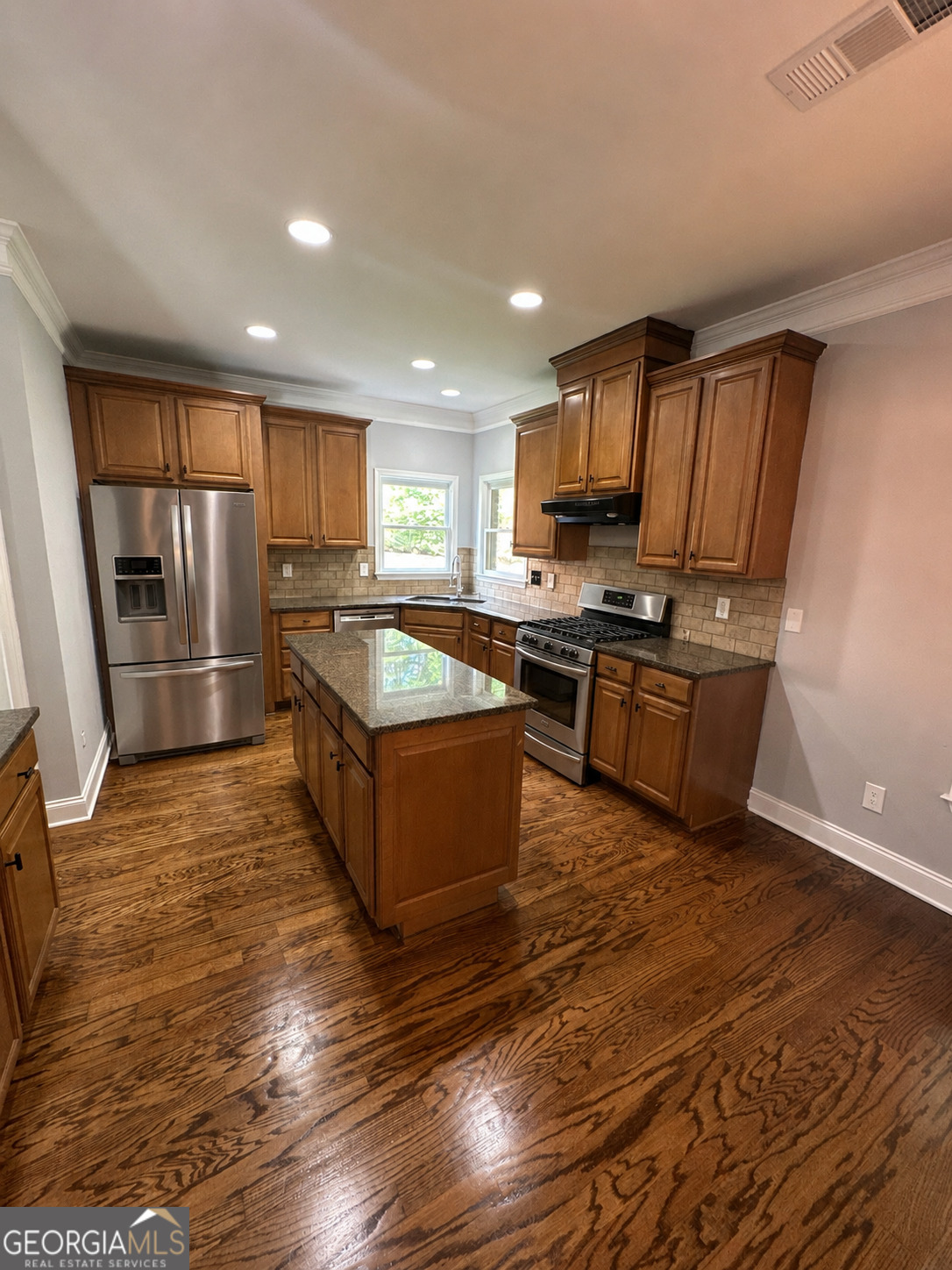2614 Dolostone Way Dacula, GA 30019 - Photo 12 of 29 a kitchen with stainless steel appliances granite countertop a stove a sink and a refrigerator