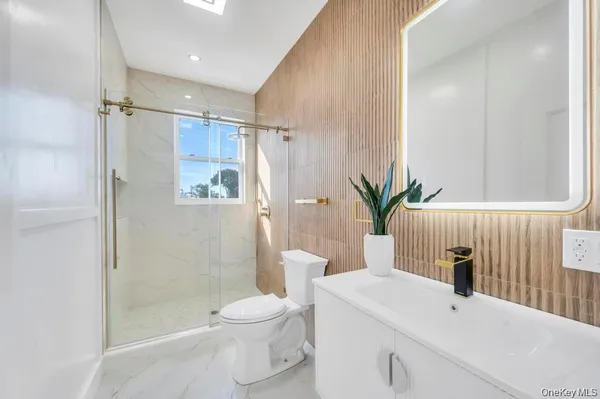 a bathroom with a sink a toilet and shower