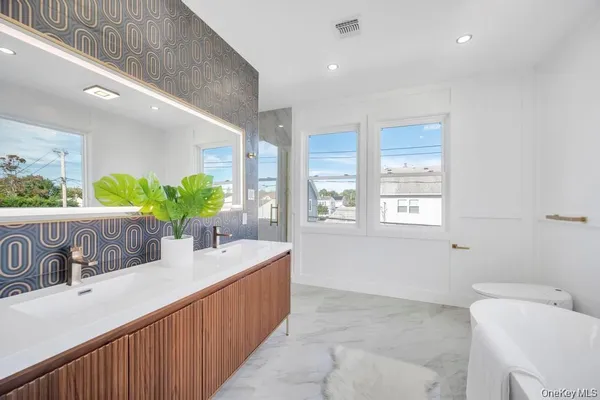 a kitchen with stainless steel appliances kitchen island granite countertop a sink and a refrigerator