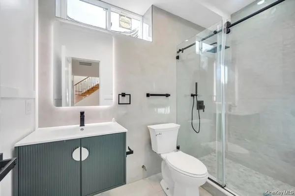 a bathroom with a sink a toilet and shower