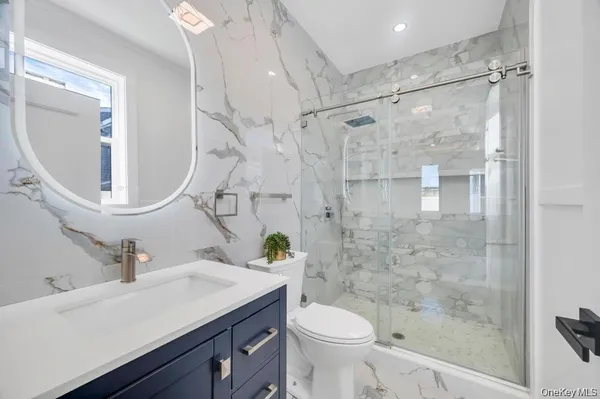 a bathroom with a sink a toilet and shower