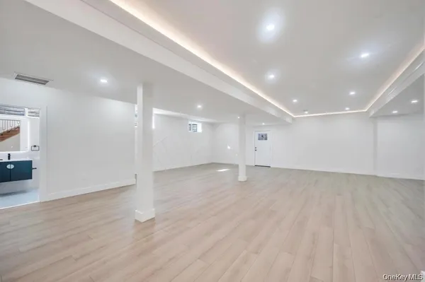 a view of an empty room with wooden floor and a fireplace