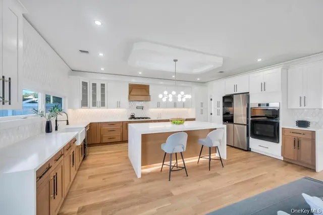a large white kitchen with lots of counter space a sink and appliances