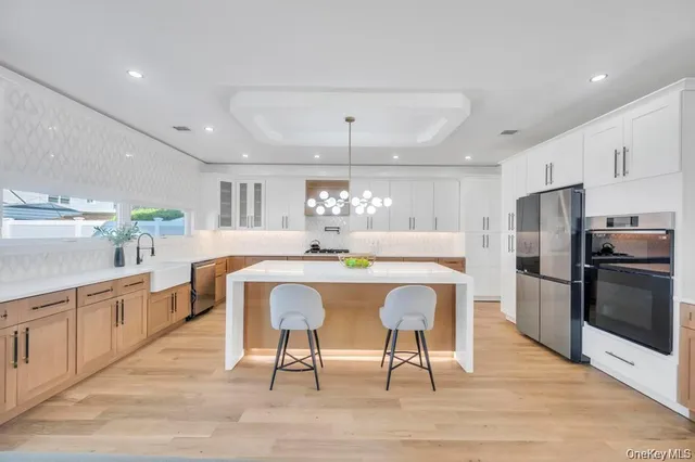 a kitchen with stainless steel appliances a dining table chairs refrigerator and cabinets