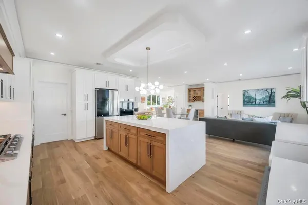 a large kitchen with stainless steel appliances granite countertop a lot of counter space and wooden floor