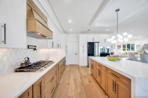 a kitchen with stainless steel appliances a sink a stove and a wooden floors