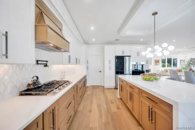 a kitchen with stainless steel appliances a sink a stove and a wooden floors
