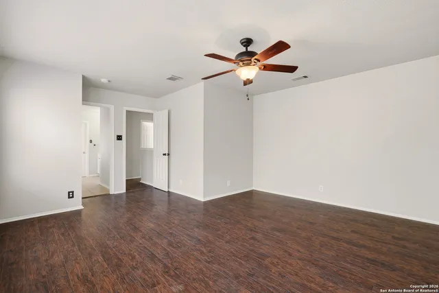 a view of an empty room with wooden floor
