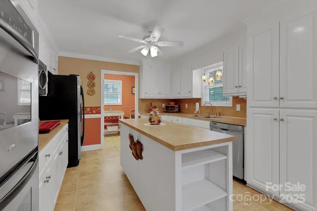 a kitchen with stainless steel appliances granite countertop a sink a stove a microwave a counter top space and cabinets