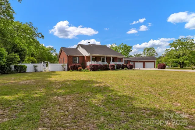 a front view of house with yard and trees around