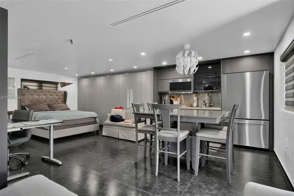 a kitchen with kitchen island stainless steel appliances a dining table and chairs