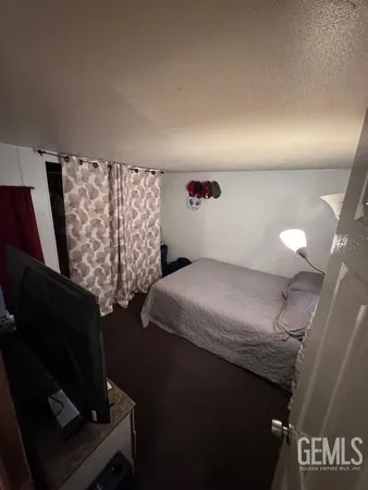 a bed room with a bed tv and a couch