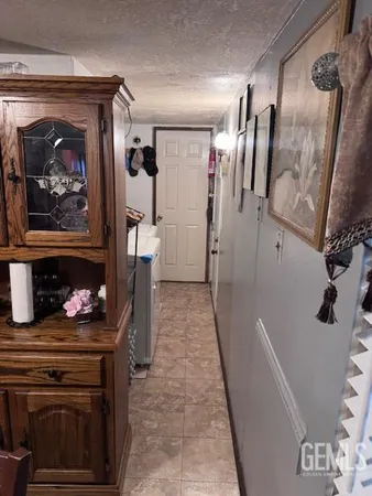 a hallway with fireplace and lots of frames on wall