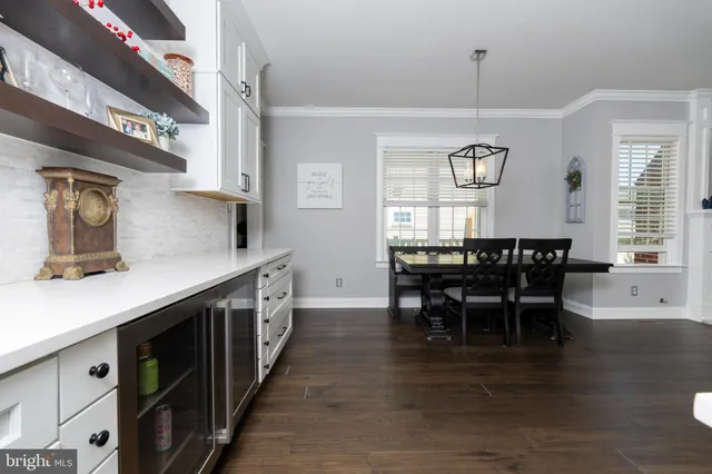 a kitchen with stainless steel appliances granite countertop a table chairs a sink and a refrigerator