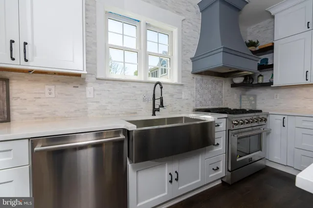 a kitchen with stainless steel appliances a sink a stove a microwave and cabinets
