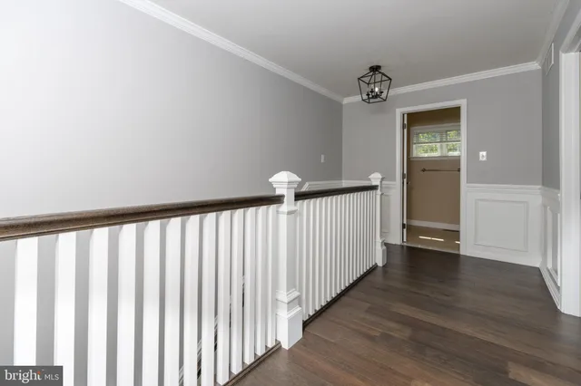 a view of a hallway with wooden floor and staircase