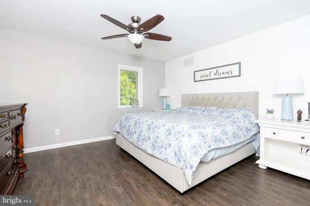 a bedroom with a bed chandelier and a window