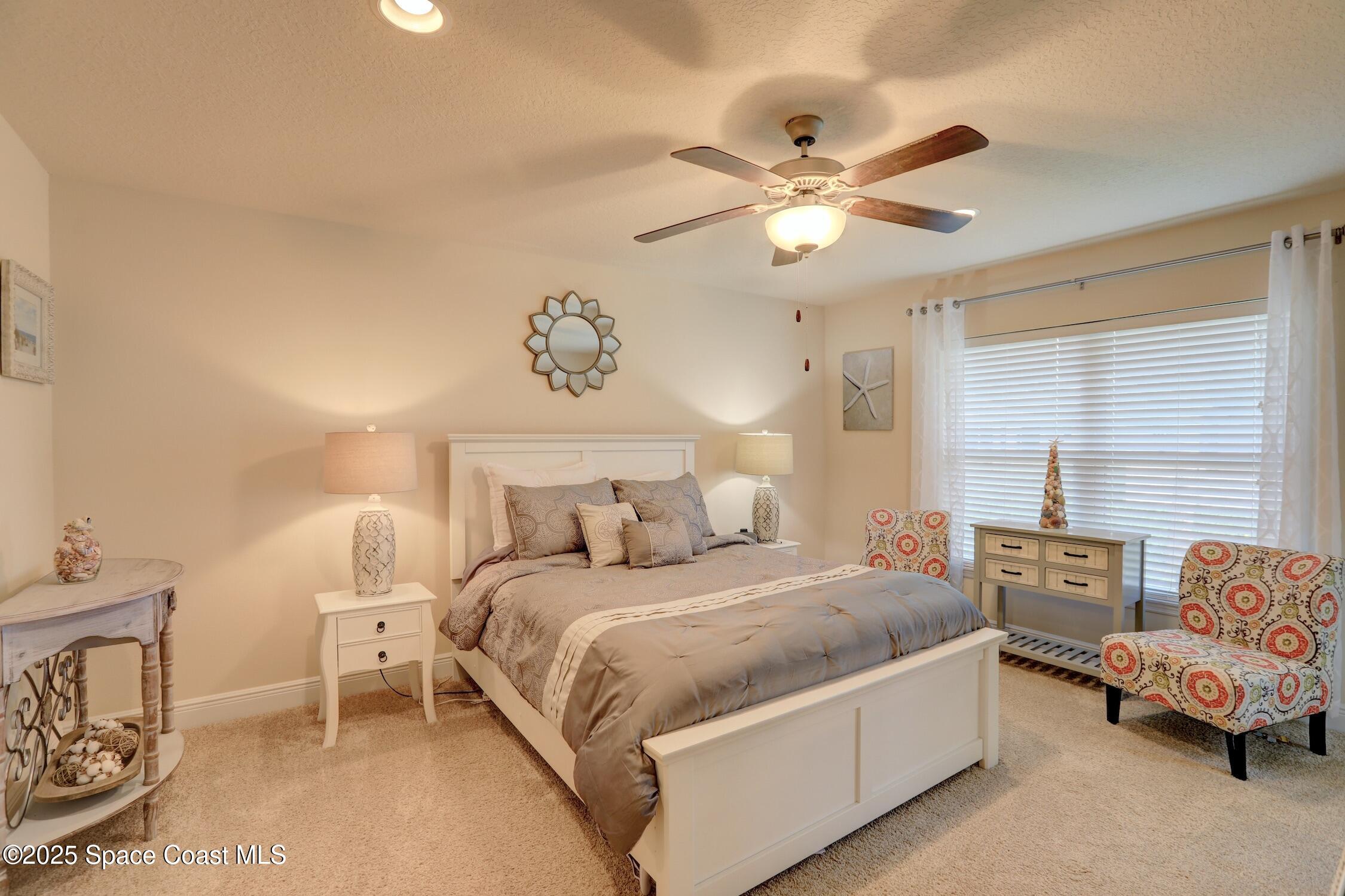 443 Lanfair Avenue Sebastian, FL 32958 - Photo 13 of 33 a bedroom with a bed and a chandelier