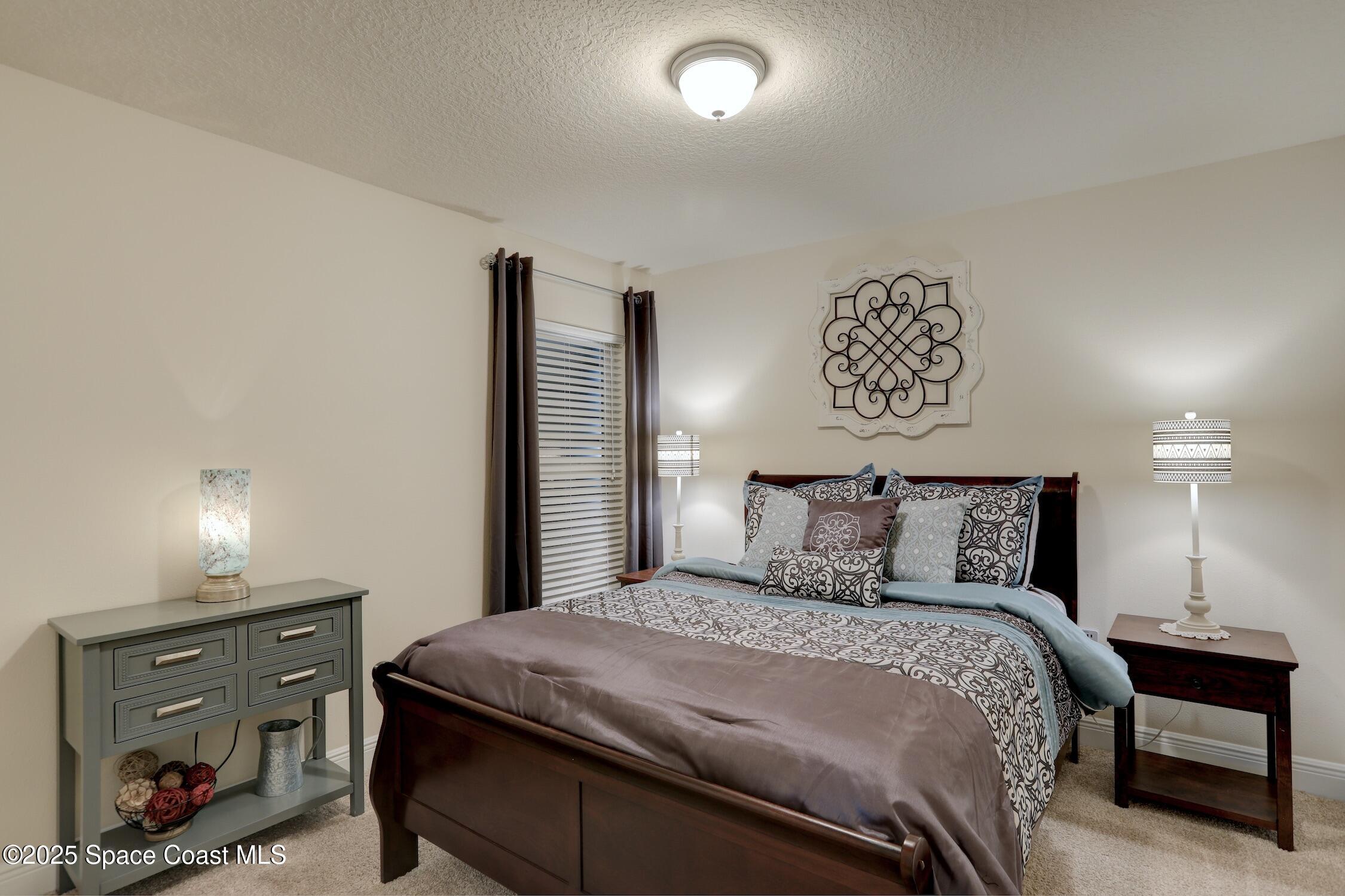 443 Lanfair Avenue Sebastian, FL 32958 - Photo 16 of 33 a bedroom with a bed and a lamp on dresser