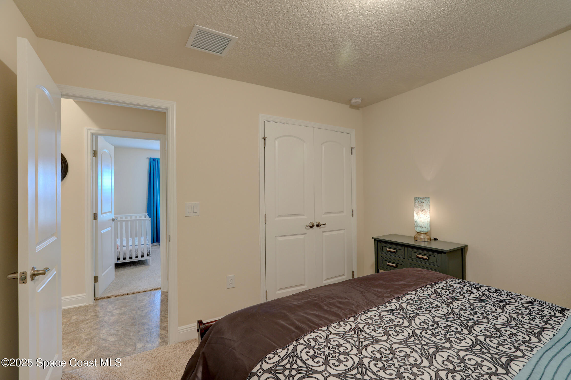 443 Lanfair Avenue Sebastian, FL 32958 - Photo 17 of 33 a bedroom with a bed and a lamp