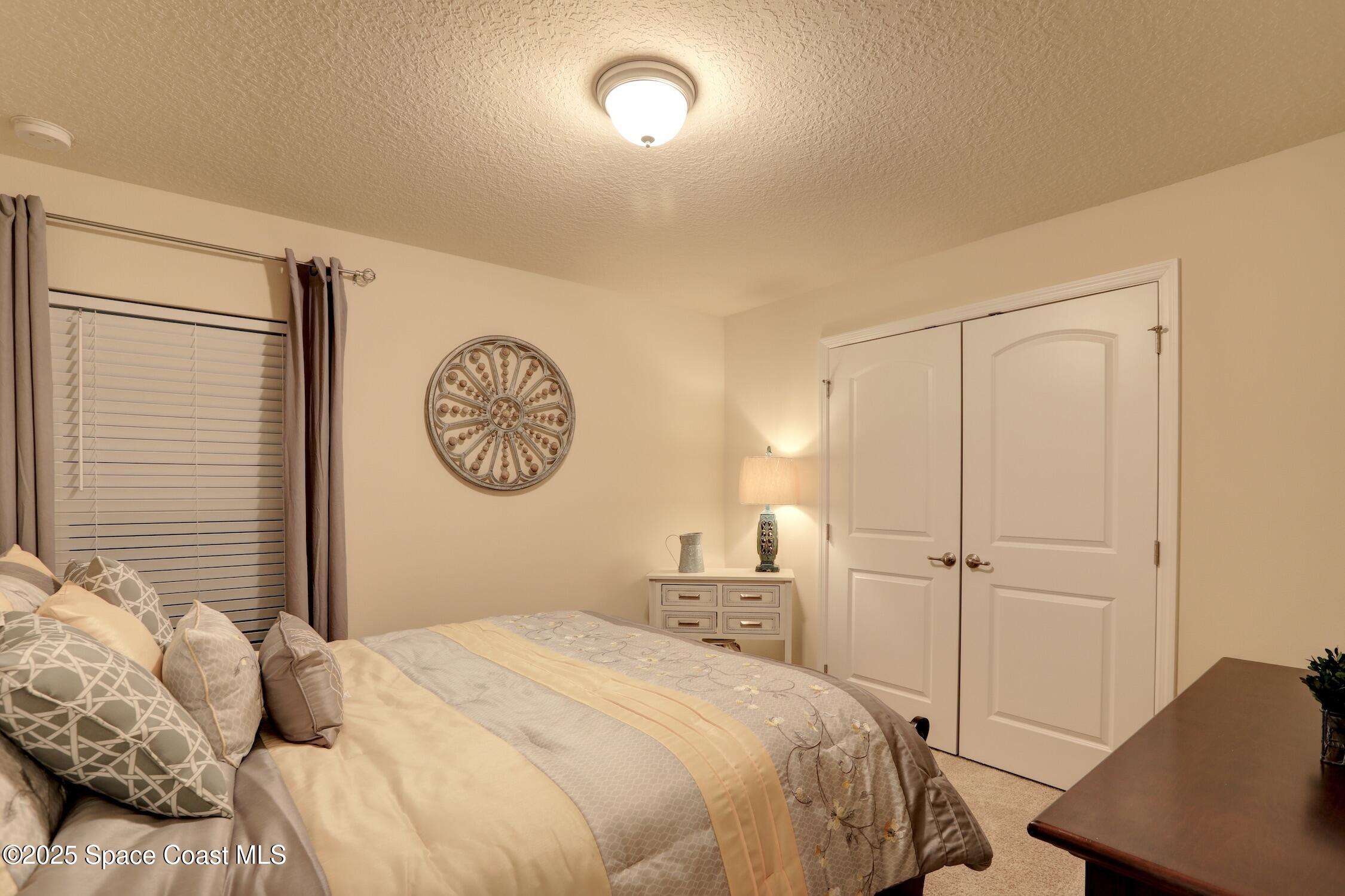 443 Lanfair Avenue Sebastian, FL 32958 - Photo 22 of 33 a bedroom with a bed and a chandelier
