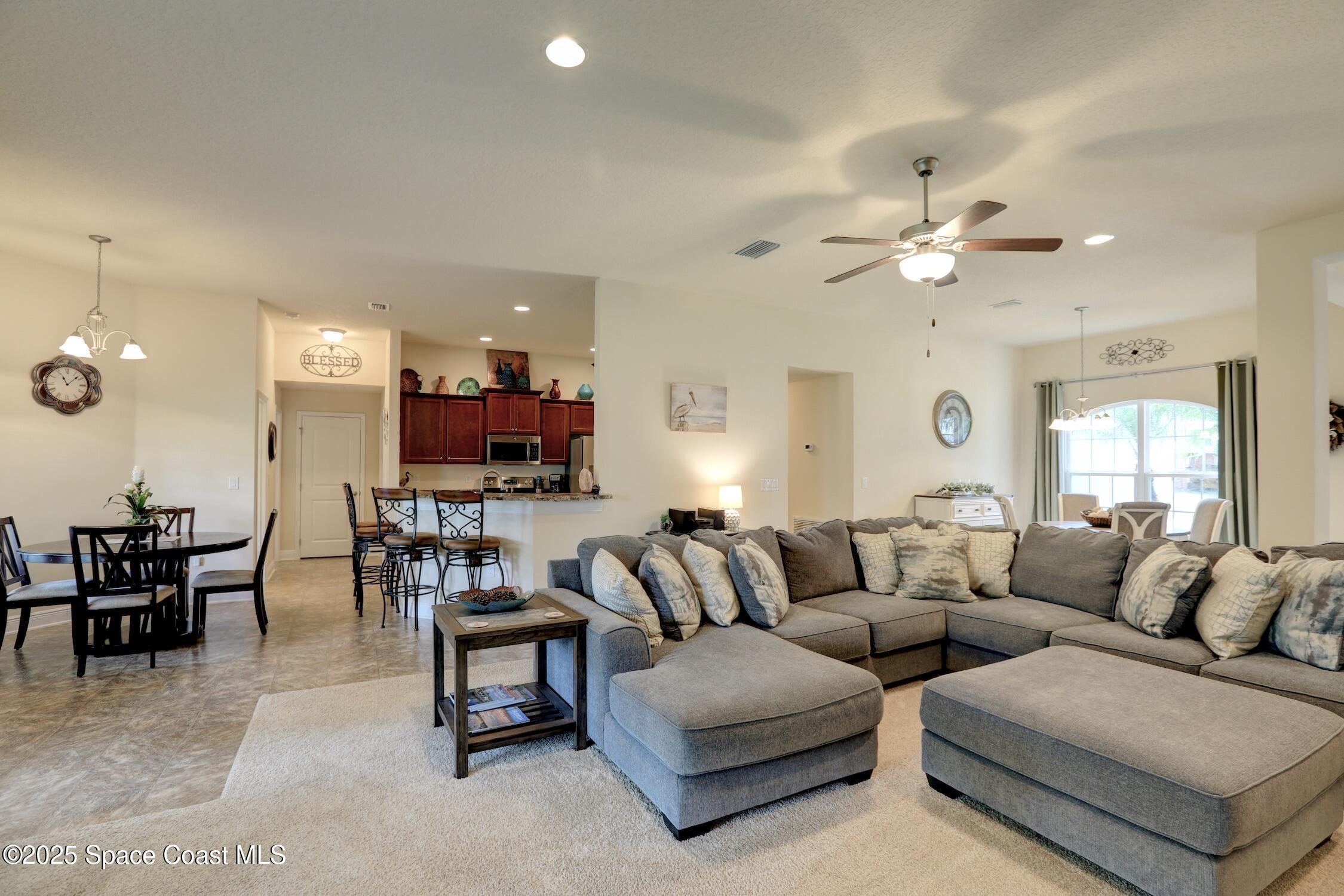 443 Lanfair Avenue Sebastian, FL 32958 - Photo 7 of 33 a living room with furniture kitchen view and a chandelier