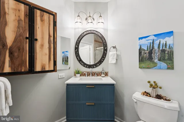 a bathroom with a toilet a sink and a mirror
