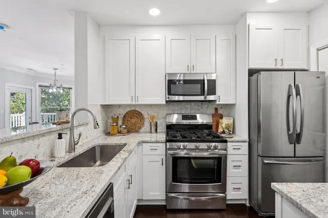 a kitchen with stainless steel appliances granite countertop a refrigerator stove and sink