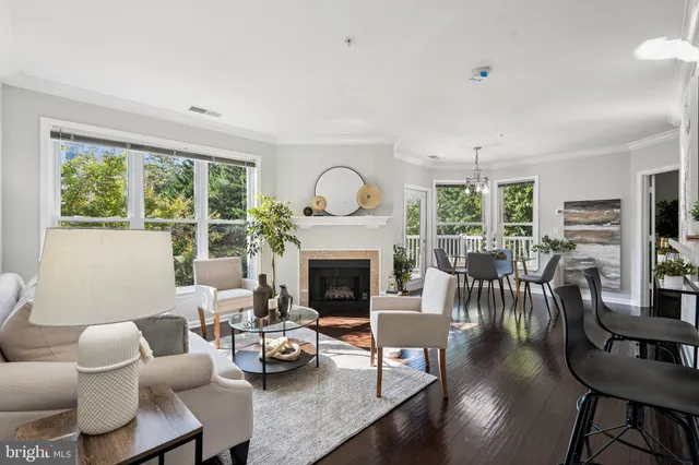 a living room with furniture fireplace and a large window