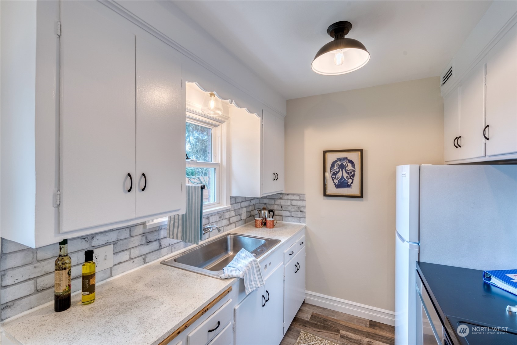 3915 Southwest Rose Street Seattle, WA 98136 - Photo 12 of 25 a kitchen with a sink stove and refrigerator