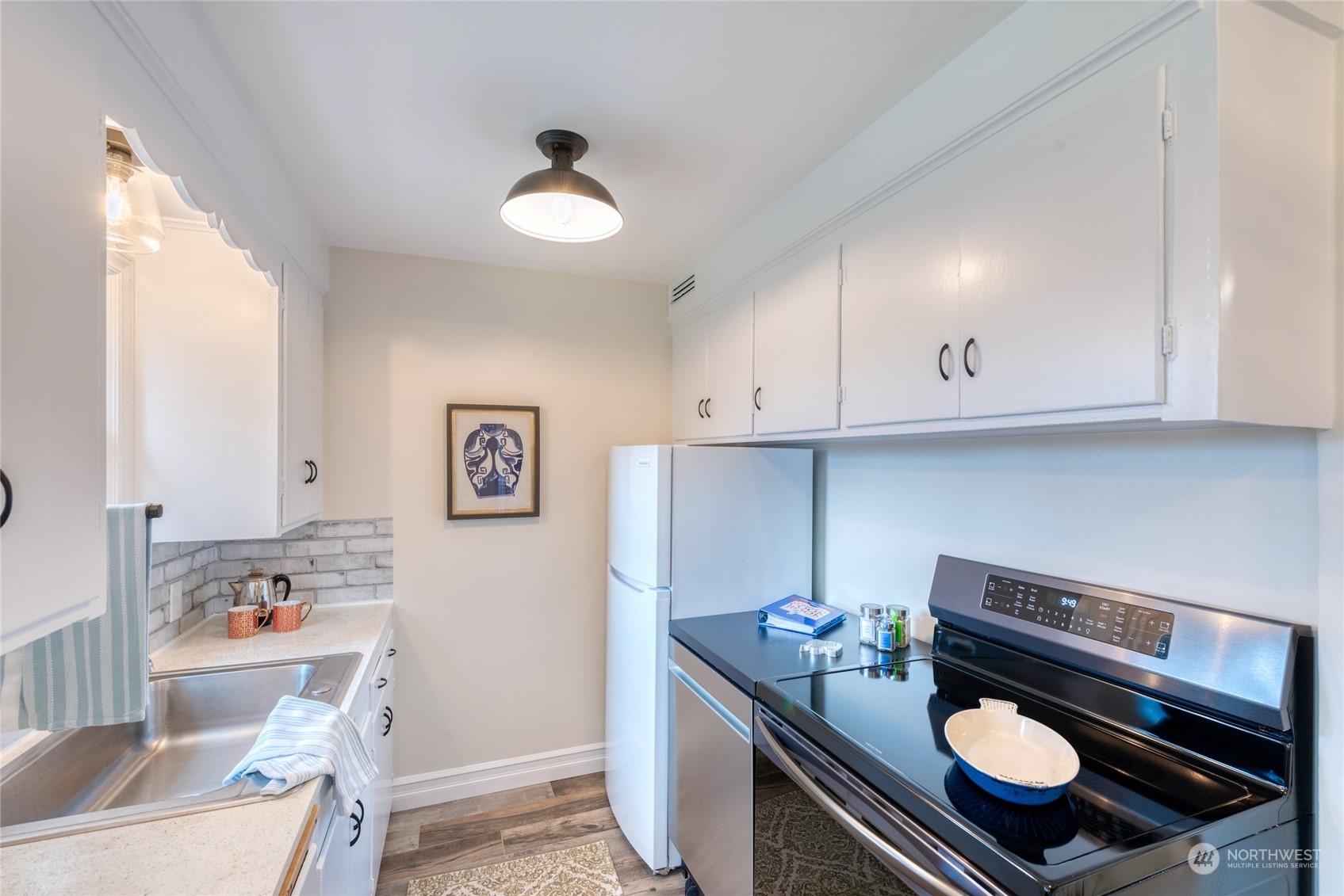 3915 Southwest Rose Street Seattle, WA 98136 - Photo 13 of 25 a kitchen with microwave a stove and cabinets