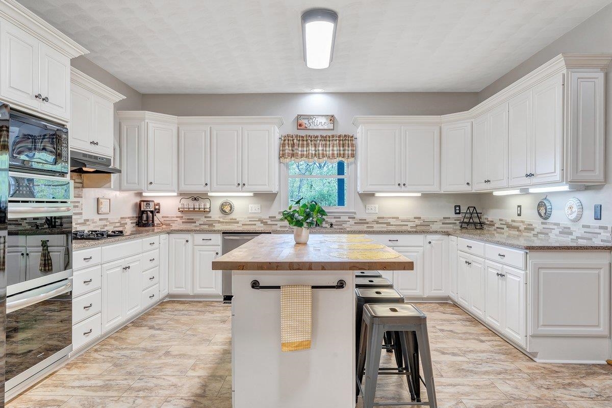 649 Greyledge Road Buchanan, VA 24066 - Photo 36 of 75 a kitchen with stainless steel appliances granite countertop a table chairs sink and cabinets